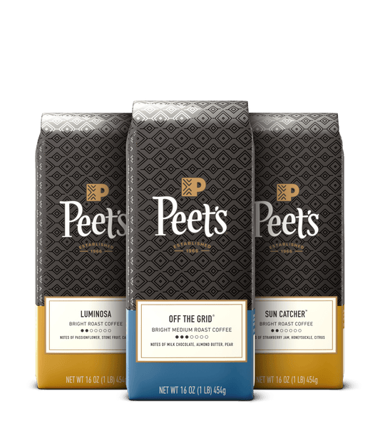 Three Peet's coffee bags with different roast labels on a black background