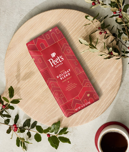 Peet's Coffee Holiday Blend package on a wooden board with American Holly